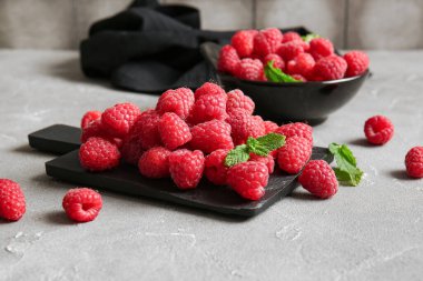 Gri masada taze ahududu tabağı ve yemek.