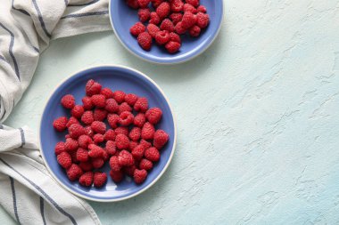 Açık mavi arkaplanda taze ahududu tabakları