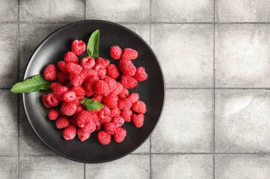 Taze ahududu tabağı ve gri fayanslı nane şekeri.