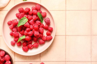 Taze ahududu tabağı ve pembe fayanslı nane şekeri.