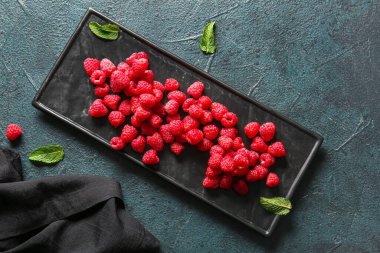 Karanlık masada taze ahududu tepsisi.