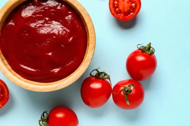 Mavi arka planda domates ezmeli ve taze sebzeli kase.