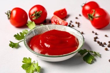 Bowl with tomato paste and fresh vegetables on grey background clipart