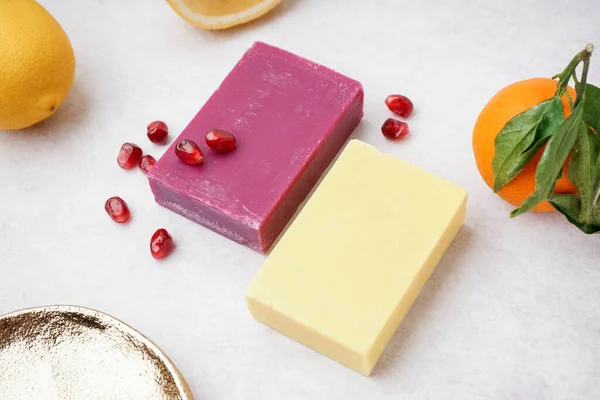 Natural soap bars and fruits on light background