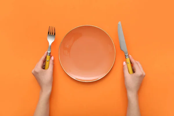 Female Hands Cutlery Empty Plate Orange Background — Stock Photo, Image