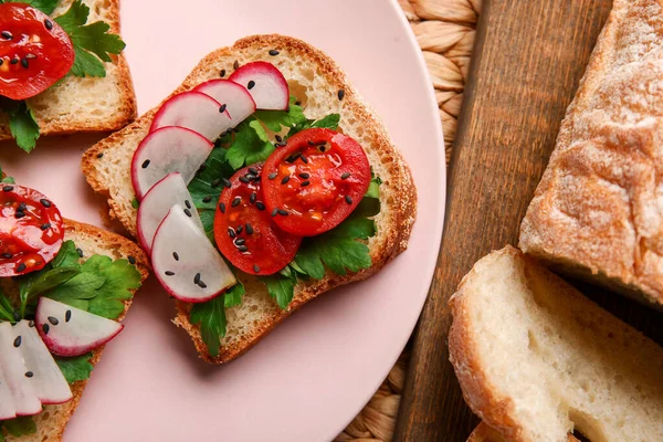 stock image Plate with delicious radish bruschettas on pink tiled table