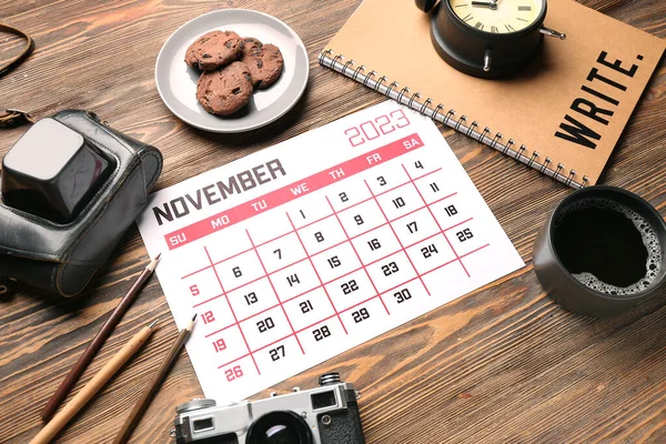 カレンダー 写真カメラ コーヒーと木製の背景にクッキーのカップと構成 — ストック写真