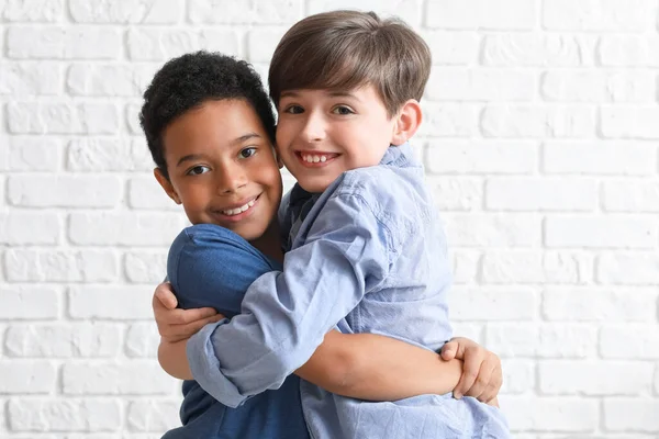 Cute Little Boys Hugging White Brick Wall Closeup — Stock Photo, Image