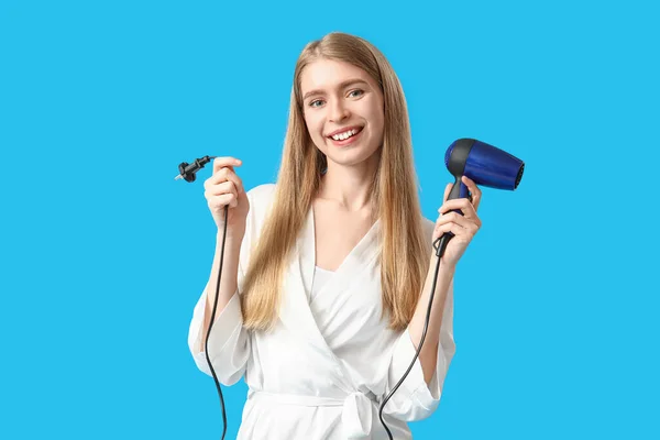 Mavi Arka Planda Saç Kurutma Makinesi Olan Genç Sarışın Kadın — Stok fotoğraf