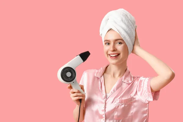 若いです女性でタオルにヘアドライヤーでピンクの背景 — ストック写真