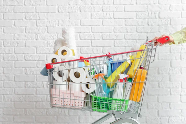 Woman Shopping Cart Full Cleaning Supplies Brick Wall — Stock Photo, Image