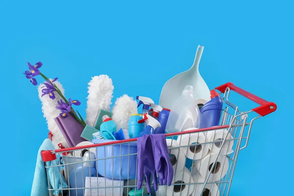 Carrinho Compras Cheio Suprimentos Limpeza Flores Roxas Fundo Azul — Fotografia de Stock