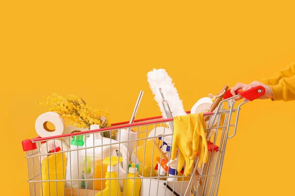 Vrouw Met Winkelwagen Vol Schoonmaakspullen Met Bloemen Gele Achtergrond — Stockfoto