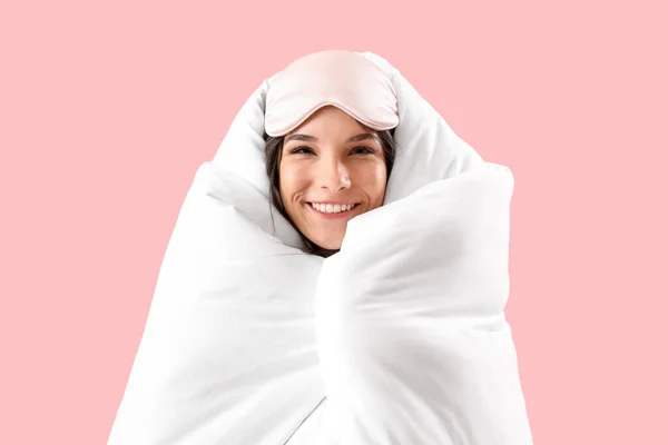 美しいです幸せな若いです女性とともに柔らかい毛布と睡眠マスク上のピンクの背景 — ストック写真