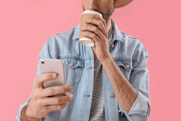 Jóképű Fiatal Férfi Mobiltelefon Iszik Kávét Rózsaszín Háttér Közelkép — Stock Fotó