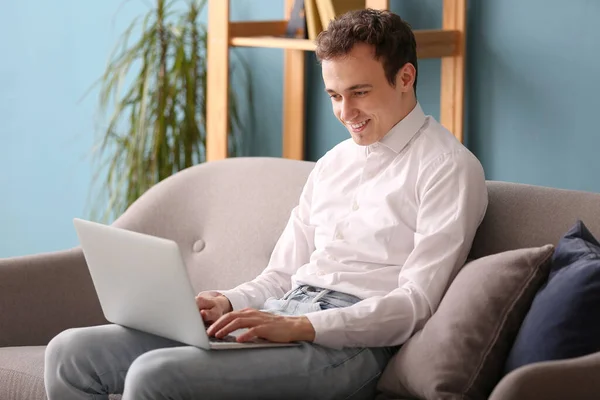 Νεαρός Άνδρας Φορητό Υπολογιστή Κάθεται Στον Καναπέ Στο Σπίτι — Φωτογραφία Αρχείου