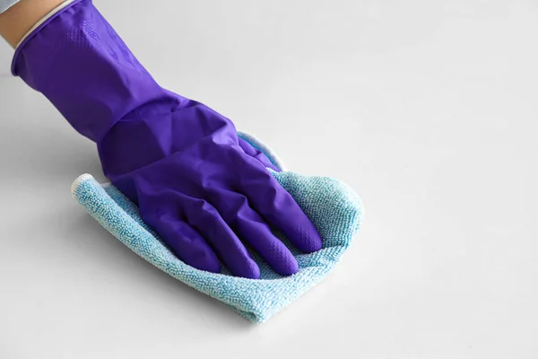 穿着紫色橡胶手套的女人用抹布擦拭桌子 — 图库照片
