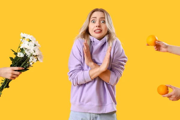 stock image Allergic young woman and female hands with allergens on yellow background