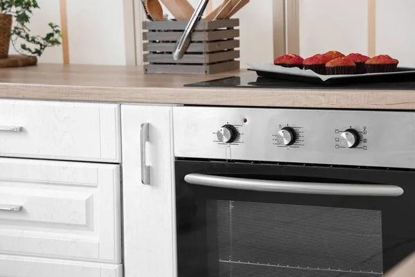 现代厨房内部的电炉和装有新鲜松饼的托盘 — 图库照片