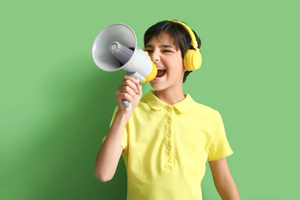 Kulaklıklı Küçük Çocuk Yeşil Arka Planda Megafona Bağırıyor — Stok fotoğraf