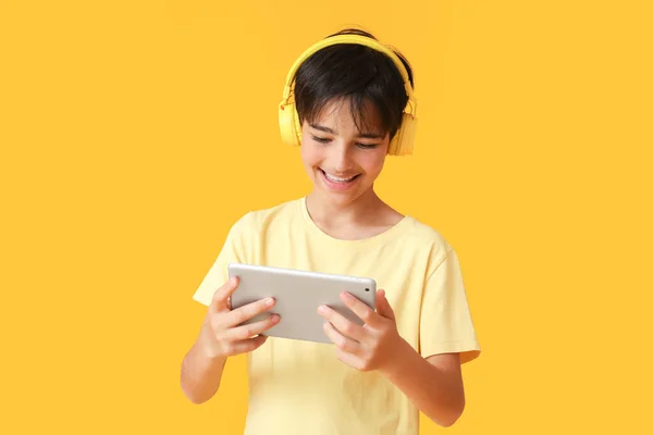 Μικρό Αγόρι Στα Ακουστικά Χρησιμοποιώντας Τον Υπολογιστή Tablet Κίτρινο Φόντο — Φωτογραφία Αρχείου
