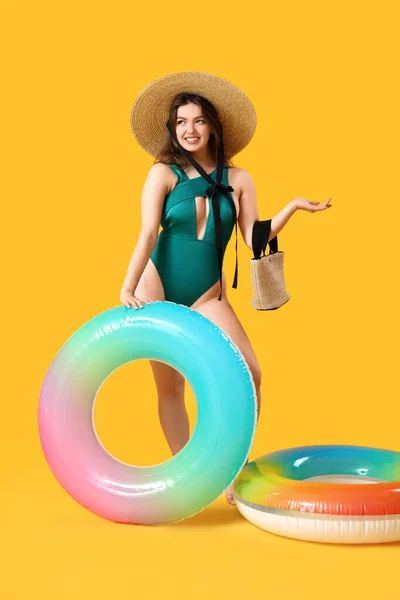 Junge Frau Mit Tasche Und Schwimmringen Auf Gelbem Hintergrund — Stockfoto