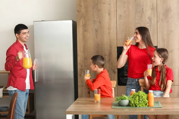 Pais Felizes Com Seus Filhos Pequenos Bebendo Suco Laranja Cozinha — Fotografia de Stock