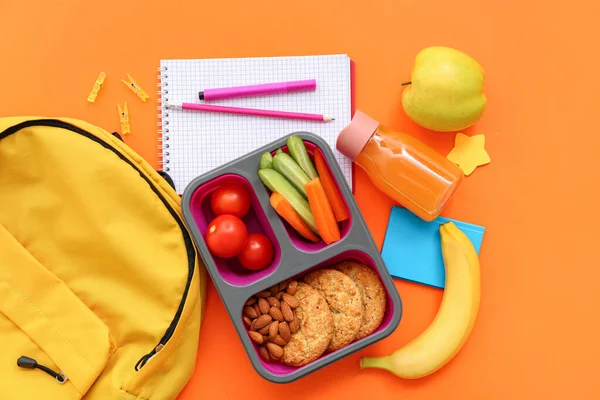 带有橙色背景食物的背包 文具和午餐盒 — 图库照片