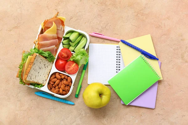 Schreibwaren Und Lunchbox Mit Leckerem Essen Auf Orangefarbenem Grunge Hintergrund — Stockfoto