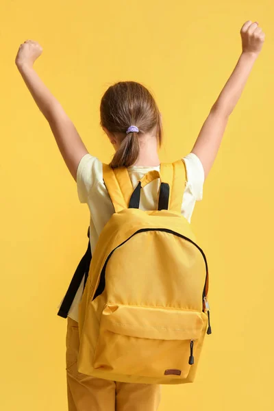 バックパック付きの小さな女の子黄色の背景 バックパックビュー — ストック写真