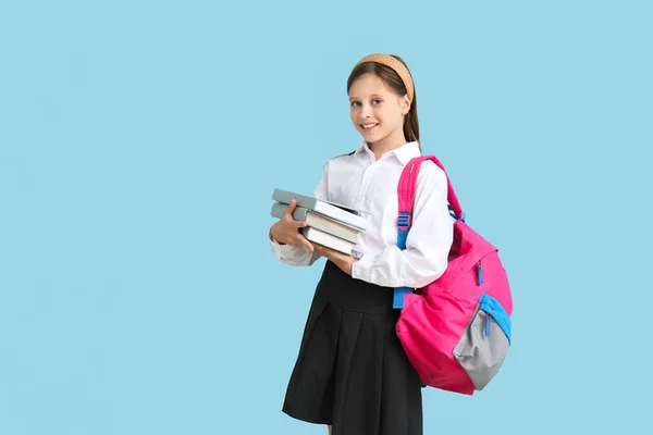 Kleines Schulmädchen Mit Büchern Und Rucksack Auf Blauem Hintergrund — Stockfoto