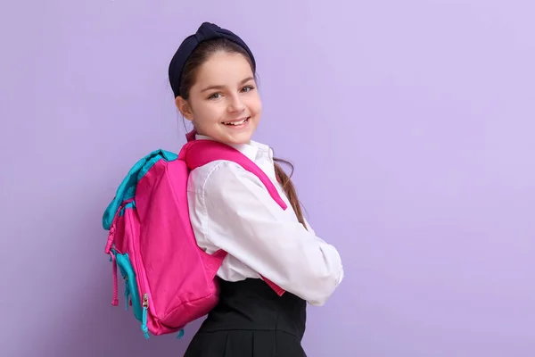 Kleine Schülerin Mit Rucksack Auf Fliederfarbenem Hintergrund — Stockfoto