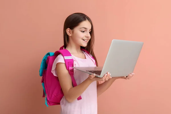 Sırt Çantalı Küçük Kız Pembe Arka Planda Dizüstü Bilgisayar Kullanıyor — Stok fotoğraf