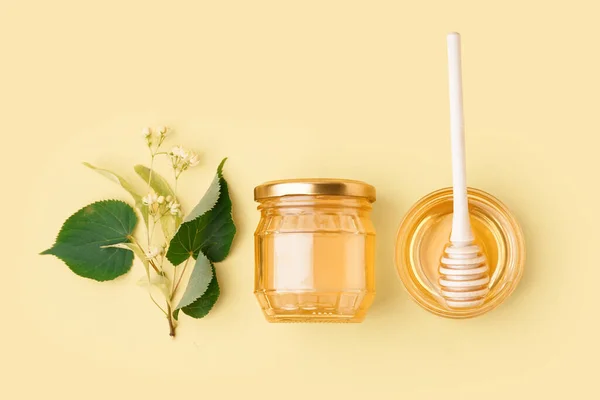 黄色の背景にリンデン蜂蜜とガラスボウルと瓶 — ストック写真