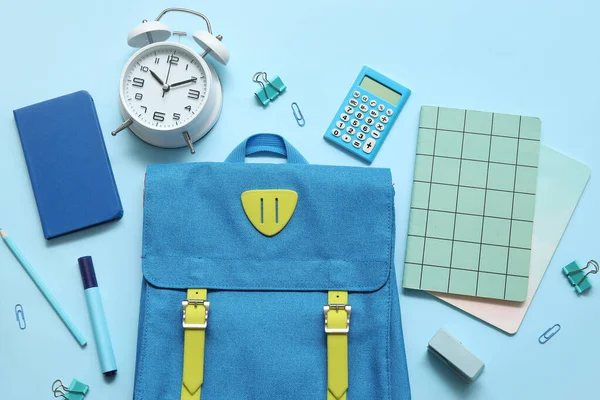 带有笔记本 闹钟和蓝色背景计算器的学校背包 — 图库照片