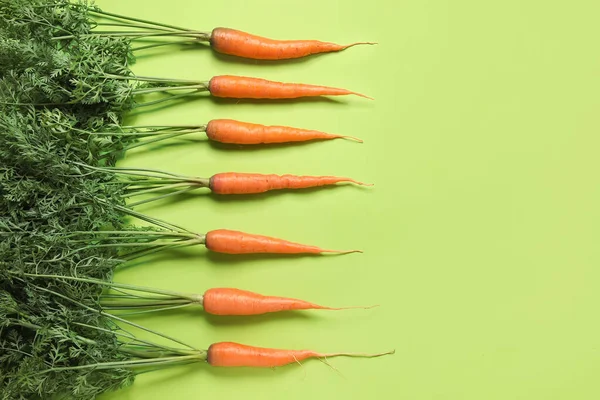 stock image Fresh carrots with leaves on green background