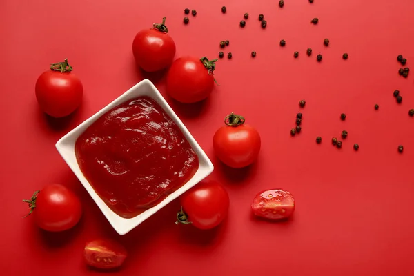 トマトペーストと新鮮な野菜を赤の背景にボウル — ストック写真