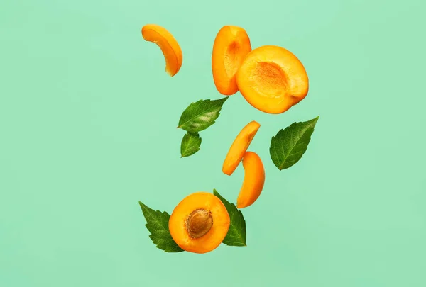 Fliegende Hälften Frischer Aprikosen Mit Stücken Und Blättern Auf Türkisfarbenem — Stockfoto