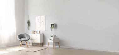 Işıl ışıl oturma odası, rahat gri koltuğu, çekmeceleri ve masası var. Tasarım için pankart