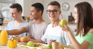 Öğrenciler okul kantininde öğle yemeği yiyor.