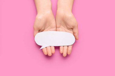 Pembe arka planda boş konuşma balonu tutan kadın