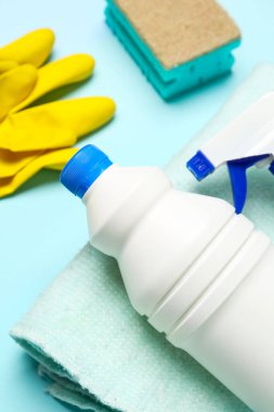Mavi arka planda farklı temizlik malzemeleri, yakın plan.