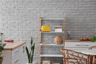 Mutfağın içinde modern ekmek kızartma makinesi ve beyaz tezgahlı raf ünitesi.