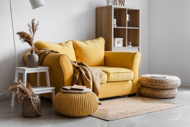 Işıl ışıl oturma odasının içinde şık sarı koltuklar ve yumuşak puflar.