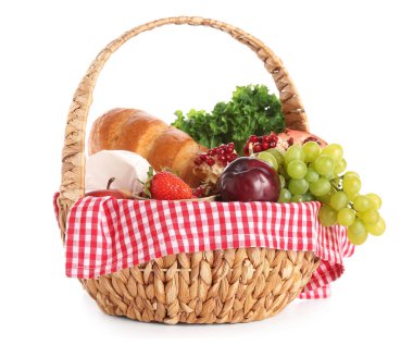 Beyaz arka planda piknik için lezzetli yiyeceklerle dolu bir sepet.