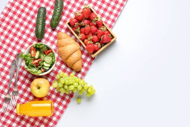 Beyaz arka planda piknik için salata, lezzetli yiyecekler ve meyve suyu.