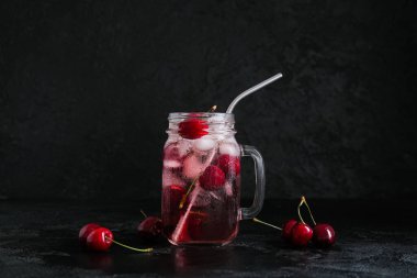 Mason kavanozu siyah arka planda vişneli limonata