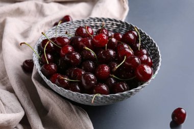 Gri arkaplanlı vişneli hasır kase.