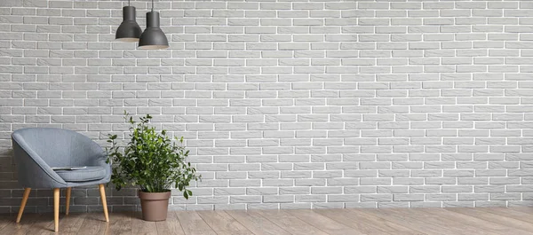 灰色のレンガの壁の近くの居心地の良いアームチェアと観葉植物 デザインのバナー — ストック写真