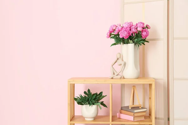 ピンクの牡丹とフィギュアの花瓶色壁の近くのドレッシング画面と棚ユニット — ストック写真